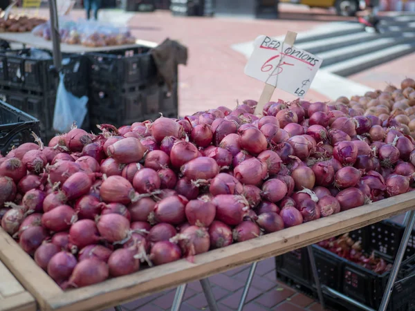 Montón de cebollas rojas para la venta en el mercado del agricultor — Foto de Stock