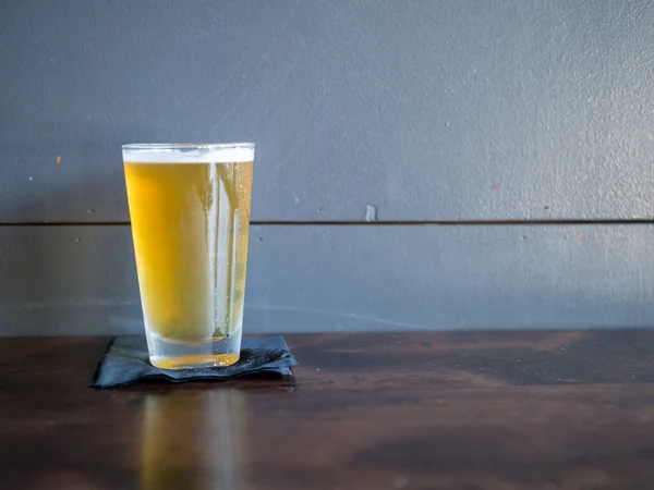 Fullt glas öl i en bar bredvid en vägg — Stockfoto
