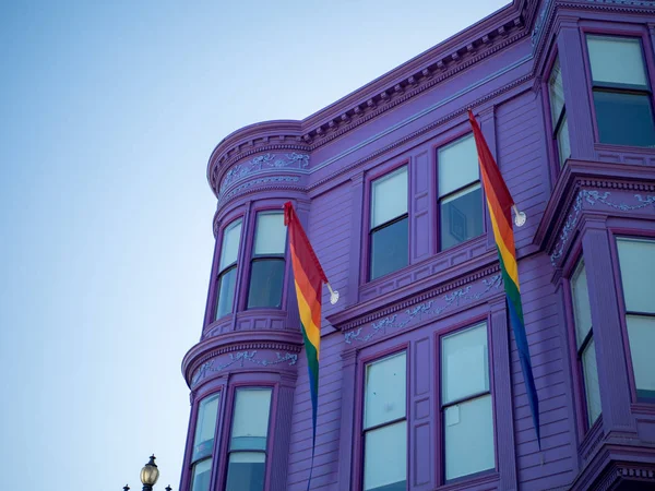 Purple house with two LGBT pride rainbow flags waving — Stock Photo, Image