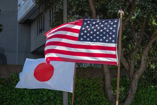 Japanese and American flags flowing in the wind