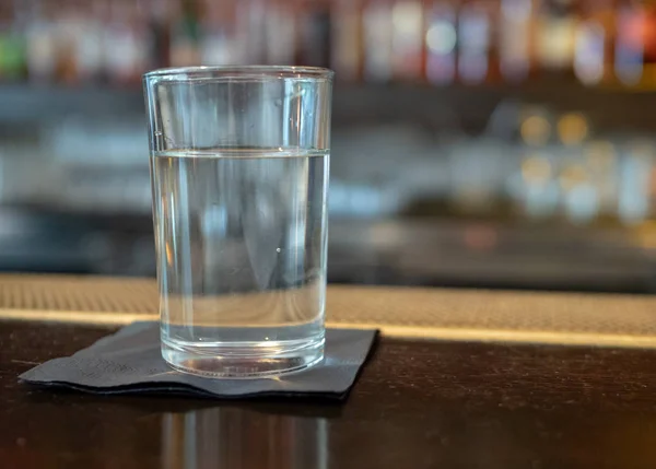 Glass of water sitting on a bar counter top