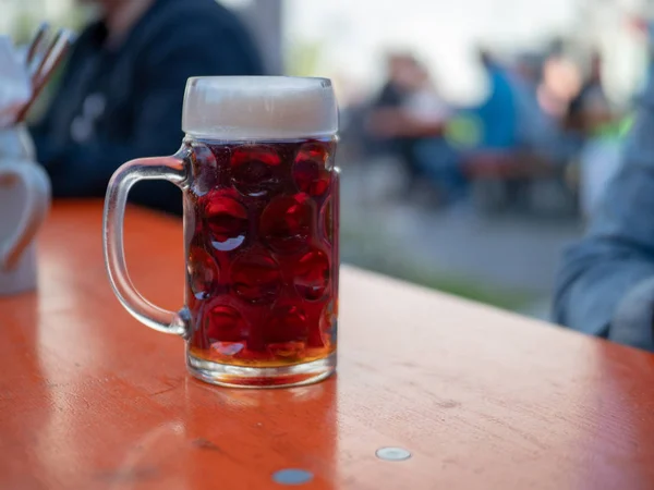 German beer mug sitting on table at outdoor event — Stock Photo, Image