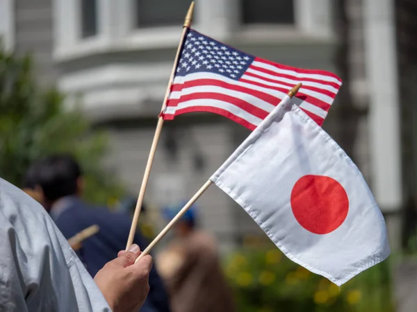 Banderas de mano de Japón y Estados Unidos ondeadas por niños — Foto de Stock