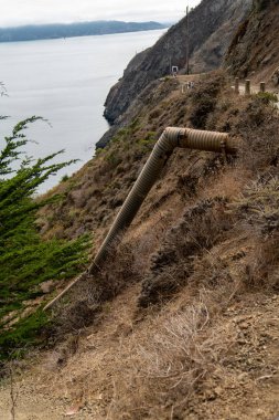 Deniz kenarındaki patika boyunca uzanan uzun drenaj borusu.