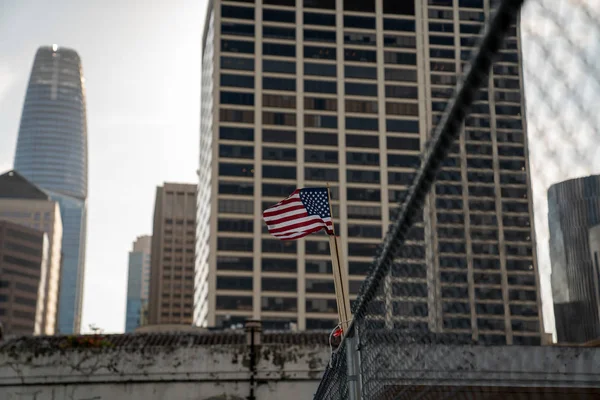 Bandera pequeña de Estados Unidos colgando de una valla en el área industrial del centro — Foto de Stock