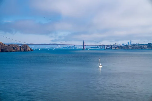 Navegación en yate frente al puente Golden Gate en aguas abiertas con horizonte de la ciudad de San Francisco — Foto de Stock