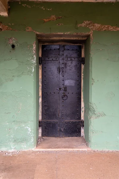 Gran puerta de acero reforzado que bloquea la entrada de un antiguo complejo penitenciario — Foto de Stock