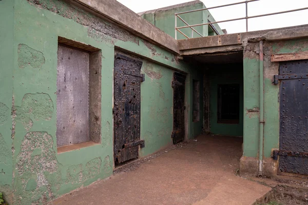 Estructura rota del edificio de la prisión con puertas oxidadas y pintura que se desmorona — Foto de Stock