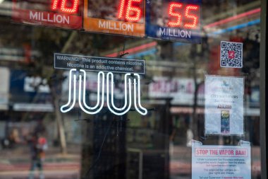 Juul e-sigara buharlaşan neon levhası. Dışarıdaki içki dükkanına nikotin uyarısı asılmış.