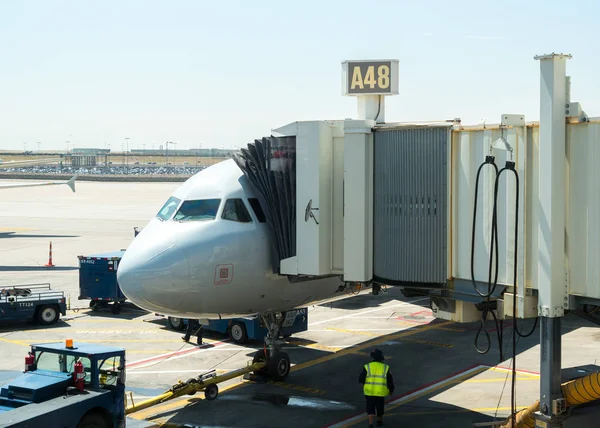 Avión atracado en la terminal del aeropuerto conectado con el puente de embarque de pasajeros que conecta para embarcar — Foto de Stock