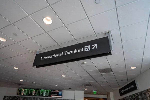 Internationale terminal met logo van de luchthaven wijst naar rechts op de luchthaven — Stockfoto