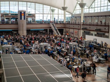 Travelers standing in long queue at TSA security checkpoint at Denver International Airport clipart