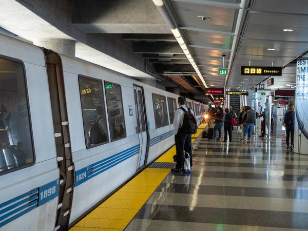 Tren de tránsito rápido del área de la bahía BART con pasajeros abordando en parada SFO — Foto de Stock