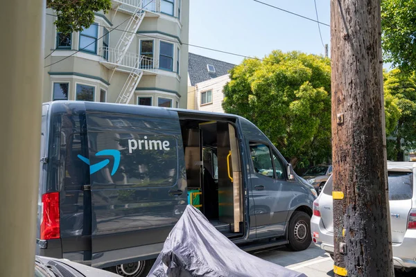 Amazon primer camión de reparto estacionado en el barrio con el conductor va de puerta en puerta — Foto de Stock