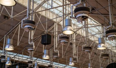 Various industrial lights hung high in bright modern warehouse