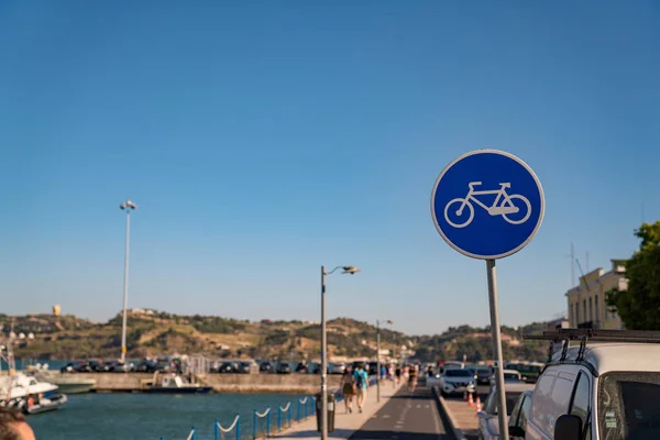 Zona de carril bici y señal de bicicleta azul en zona peatonal cerca de la bahía — Foto de Stock