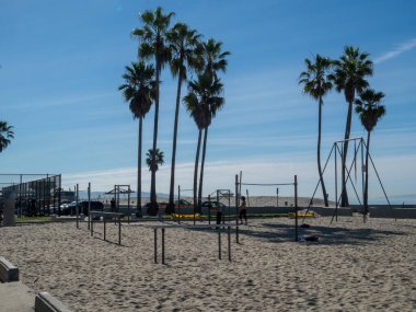 Venice Beach Muscle Sahili 'nin açık kum havuzu bölgesinde erkekler antrenman yapıyor.