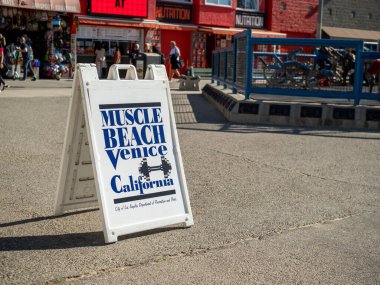 Muscle Beach Venice Plajı tabelası açık hava spor salonunun yanında.