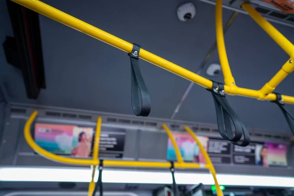 Correas de muñeca suspendidas del carril de seguridad en el autobús de transporte público — Foto de Stock