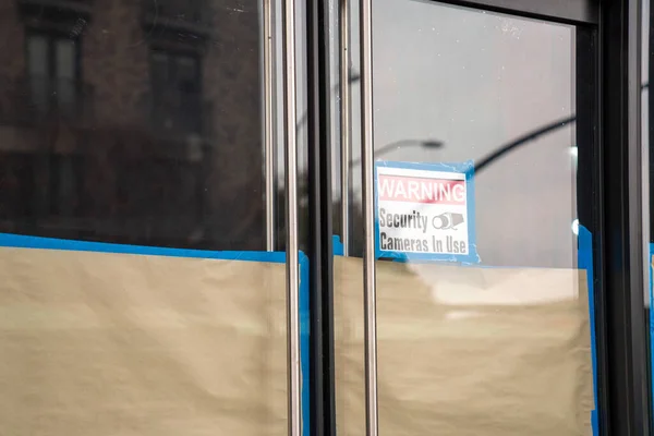 Попереджувальні камери безпеки у використанні знака на скляних дверях у будівлі з ремонтом — стокове фото