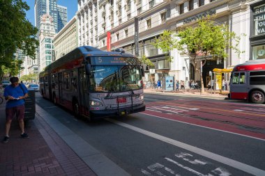 Muni otobüsü Fulton Hattı 5 Market Caddesi alışveriş bölgesindeki kişiyi geçiyor.