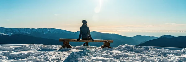 Bella donna bruna adulta siede su una panchina in alta montagna — Foto Stock
