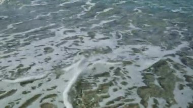 Tropik plaj, yakın manzara, dalgaların tepesi sarı kumsalda kırılıyor..