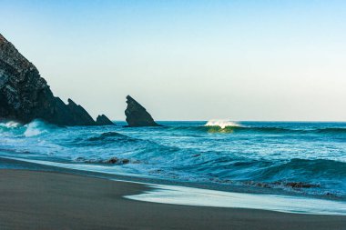 Güneş doğarken düşen okyanus dalgaları. Sörf dalgalarında gün doğumu