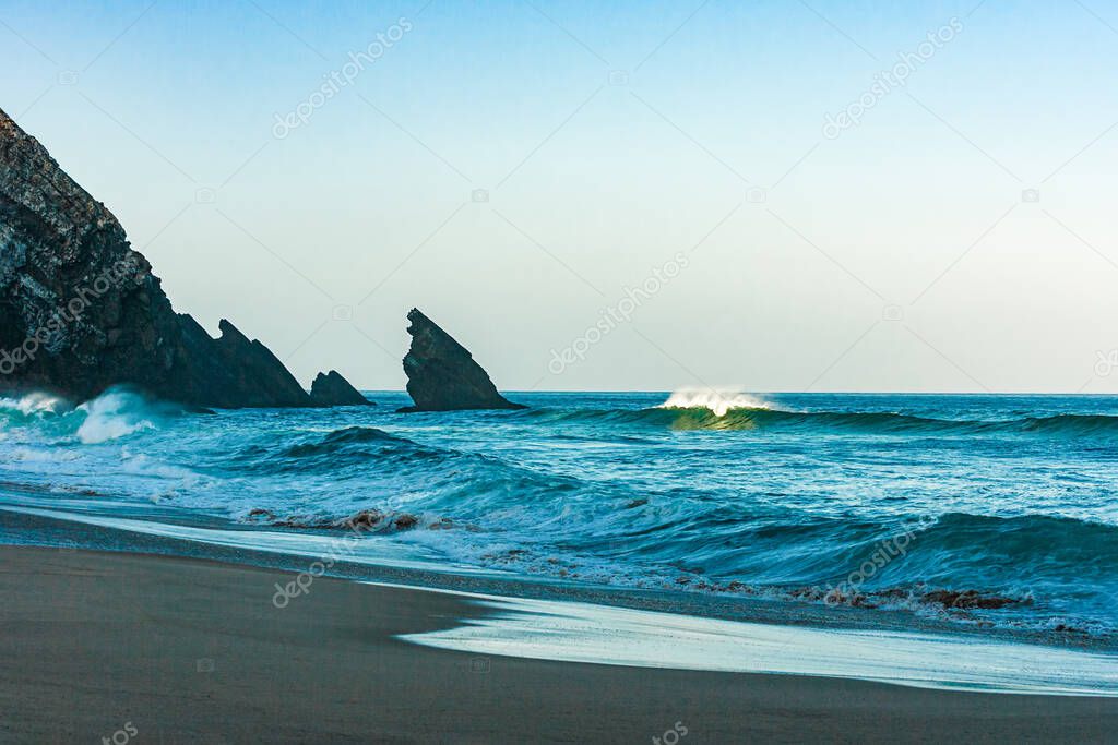Breaking ocean wave falling down at sunrise time landscape. Sunrising sunlight on surf waves
