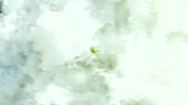 Devasa okyanus dalgalarının çarpışma ve köpürme görüntülerinin yukarıdan aşağıya doğru görüntüsü. Yavaş çekim