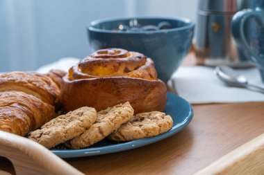 Kahvaltınız ahşap tepside, kahve ve kruvasanlarla servis edilir. Günaydın konsept.