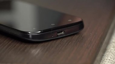 Bir erkeğin parmakları kabloyu akıllı telefona bağlar.