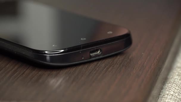 Close-up van een mans vingers verbindt de kabel met de smartphone — Stockvideo