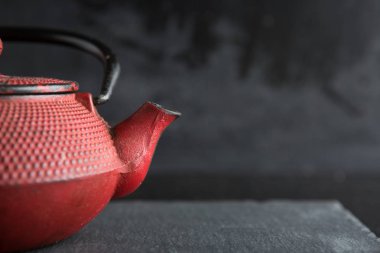 Koyu renk arka plan üzerinde kırmızı demir demlik