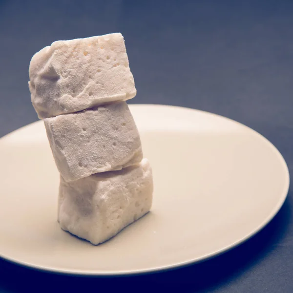 Cubos de marshmallow na placa branca — Fotografia de Stock