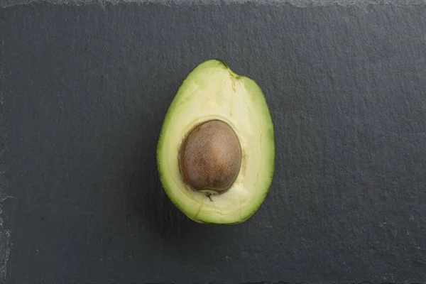 Нарезанный авокадо на каменном фоне — стоковое фото