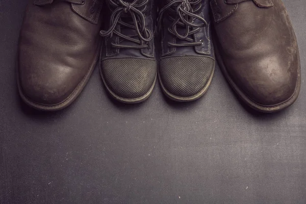 Daddy's boots and baby's shoes, fathers day concept. — Stock Photo, Image