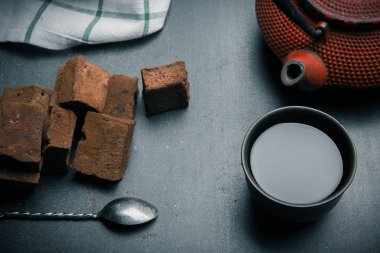 Çikolata marshmallow ile baharat siyah masa üzerinde. Tarçın, yıldız anason, çaydanlık