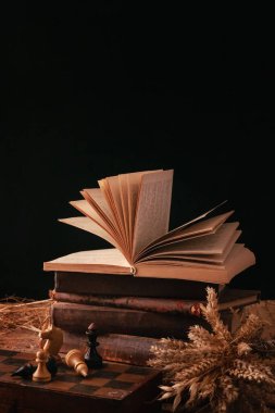 Siyah arka plandaki eski kitaplar. Eğitim ve bilgi kavramı. Öğrenmenin sembolü