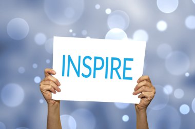 Işık arka plan ile Inspire kartı tutan el.