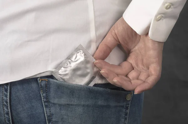 Preservativo no bolso de jeans azuis . — Fotografia de Stock