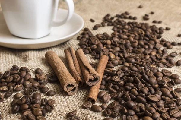 Close up of fragnant cinnamon sticks with coffee beans and cup o — Stock Photo, Image