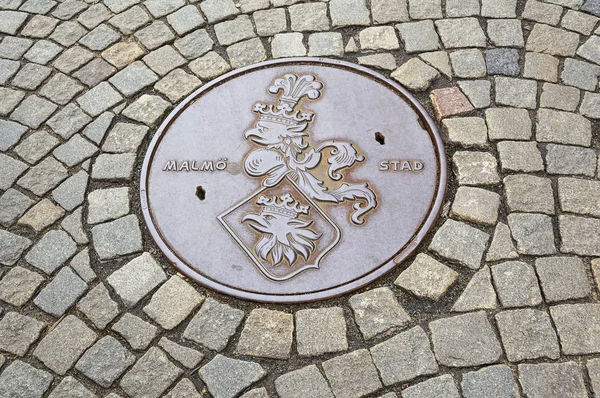 Manhole cover on cobbled road in Malmo Sweden.