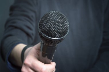 Gazeteci konuşma mikrofon ve konsantrasyon el hareketi el ile yapma