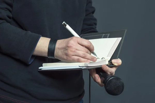 Journalist bij de persconferentie, schrijven van notities, het houden van de microfoon — Stockfoto