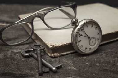 Natürmort eski cep saati ile rezervasyon yaptırın. anahtarları ve ahşap üzerine gözlük