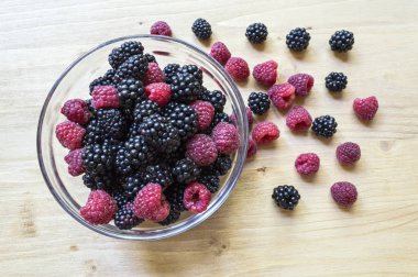 Ahududu ve böğürtlen ahşap bir masa üzerinde cam kavanozda.