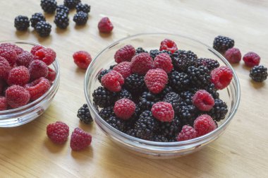 Ahududu ve böğürtlen ahşap bir masa üzerinde cam kavanozda.