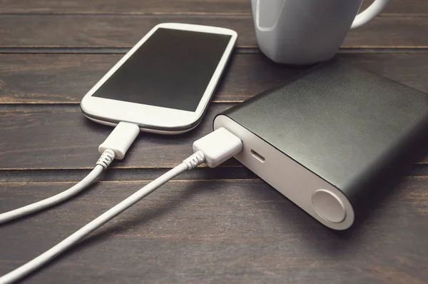 Bir fincan kahve yanında bir akıllı telefon şarj güç banka