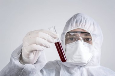 Koruyucu elbise giymiş ve tüp bebek inceleyerek bilim adamı.